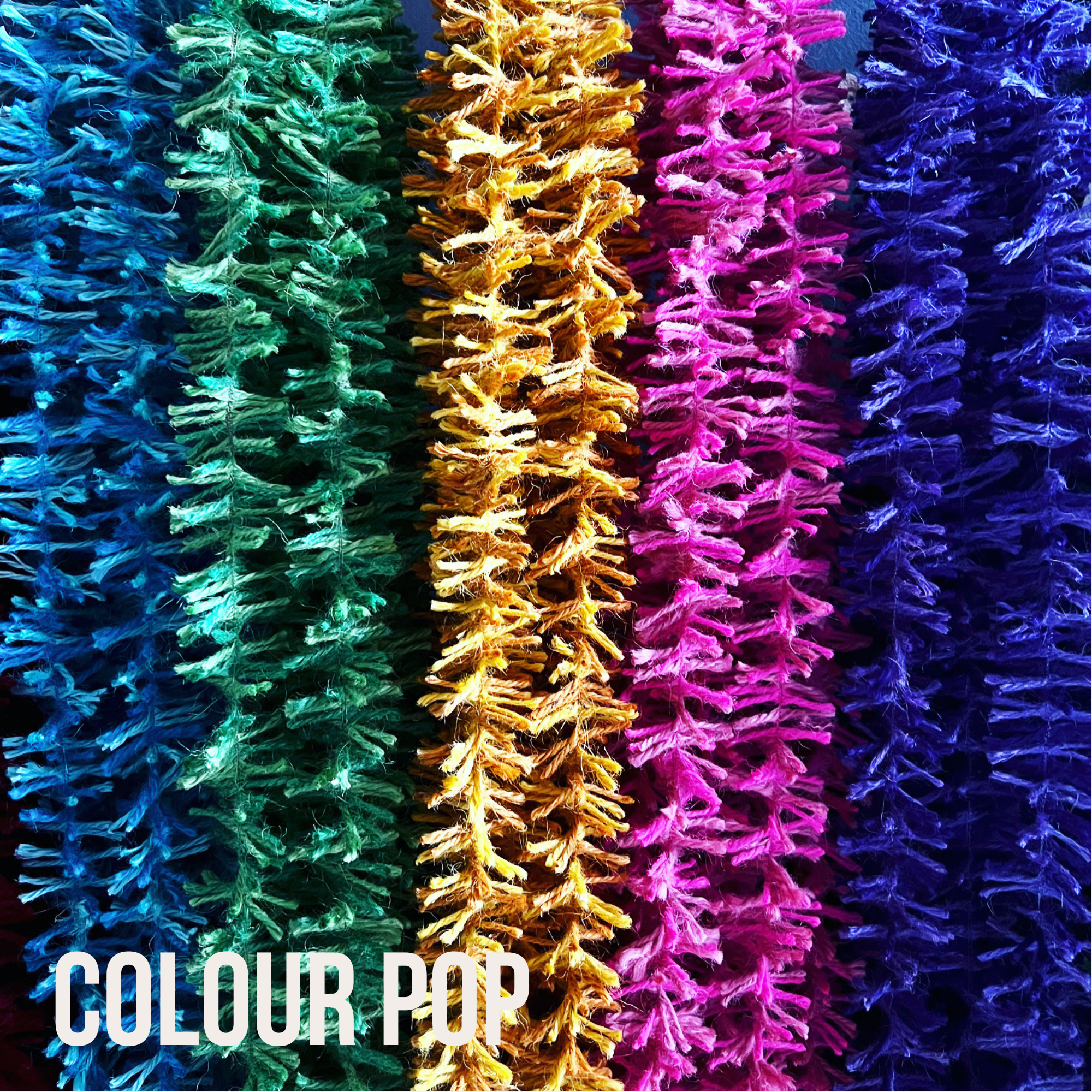 Neon blue, emerald green, bright yellow, hot pink and vivid purple Strinsel string tinsel laid out in a row with the label Colour Pop in white in the bottom left corner