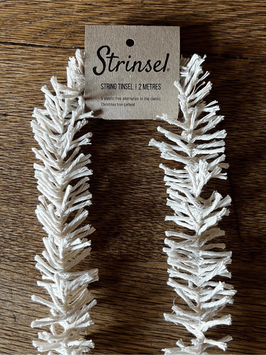 White string tinsel with a 'Strinse!' label on a wooden surface