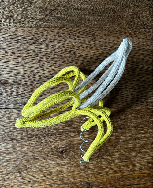 French knitted string and wire sculpted banana tree topper on a wooden background
