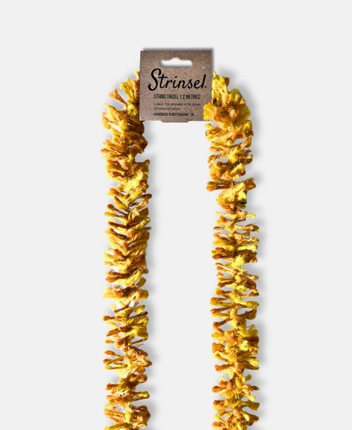 Bright gold Strinsel jute string tinsel with packaging on a pale grey background