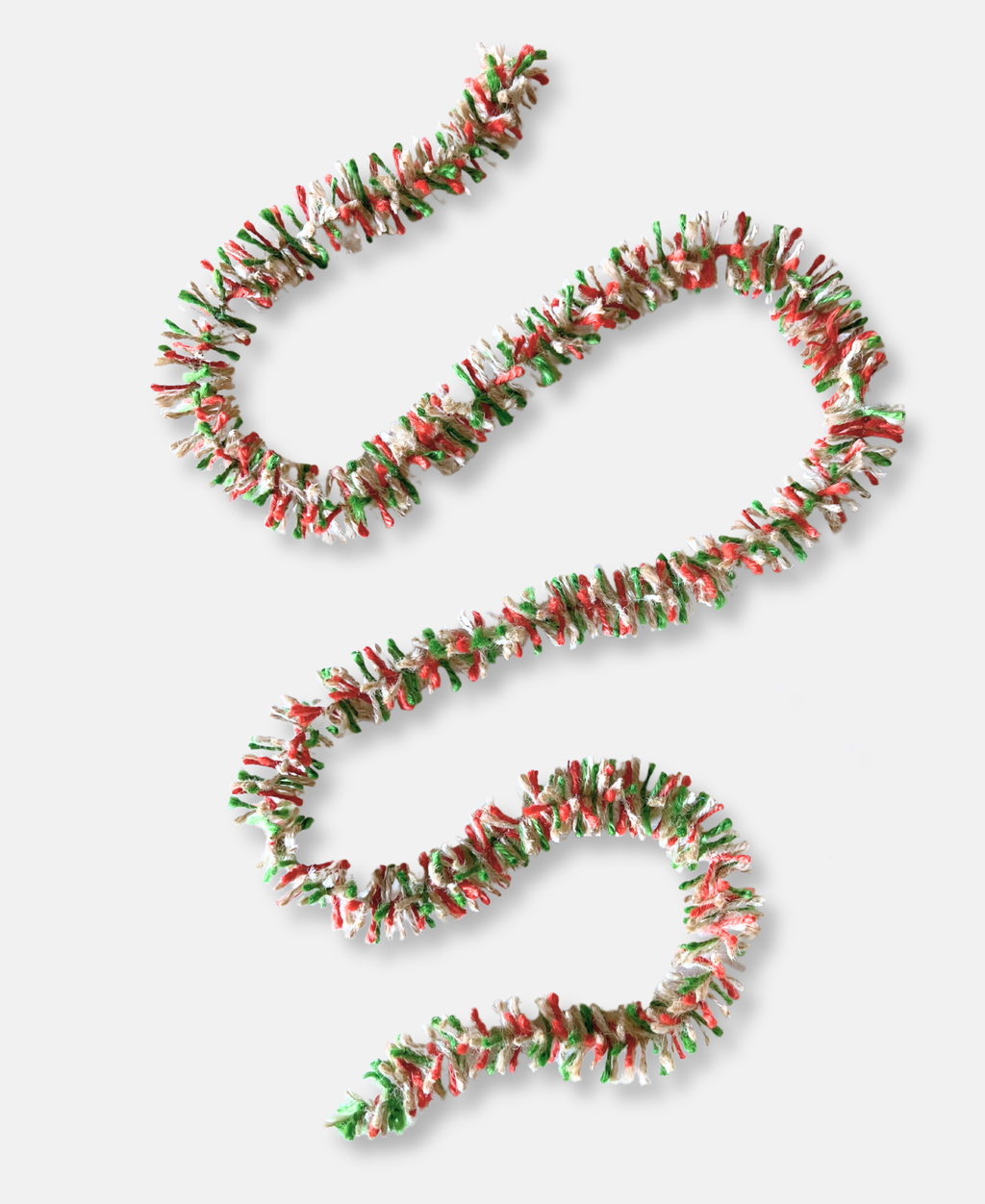 Red, white and green striped jute Strinsel string tinsel draped randomly on a white background