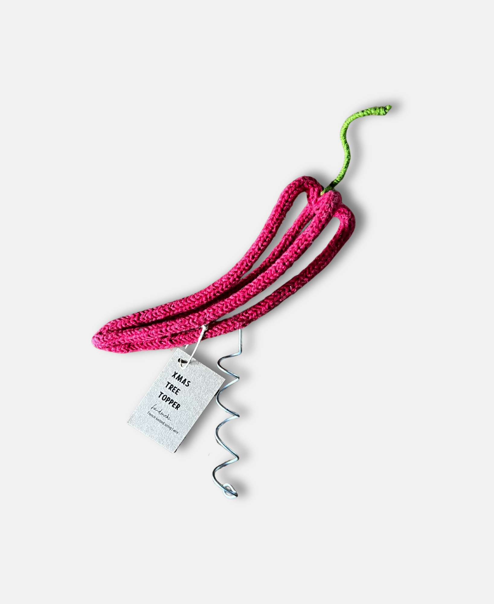 French knitted and wire sculpted red chilli tree topper against a pale grey background