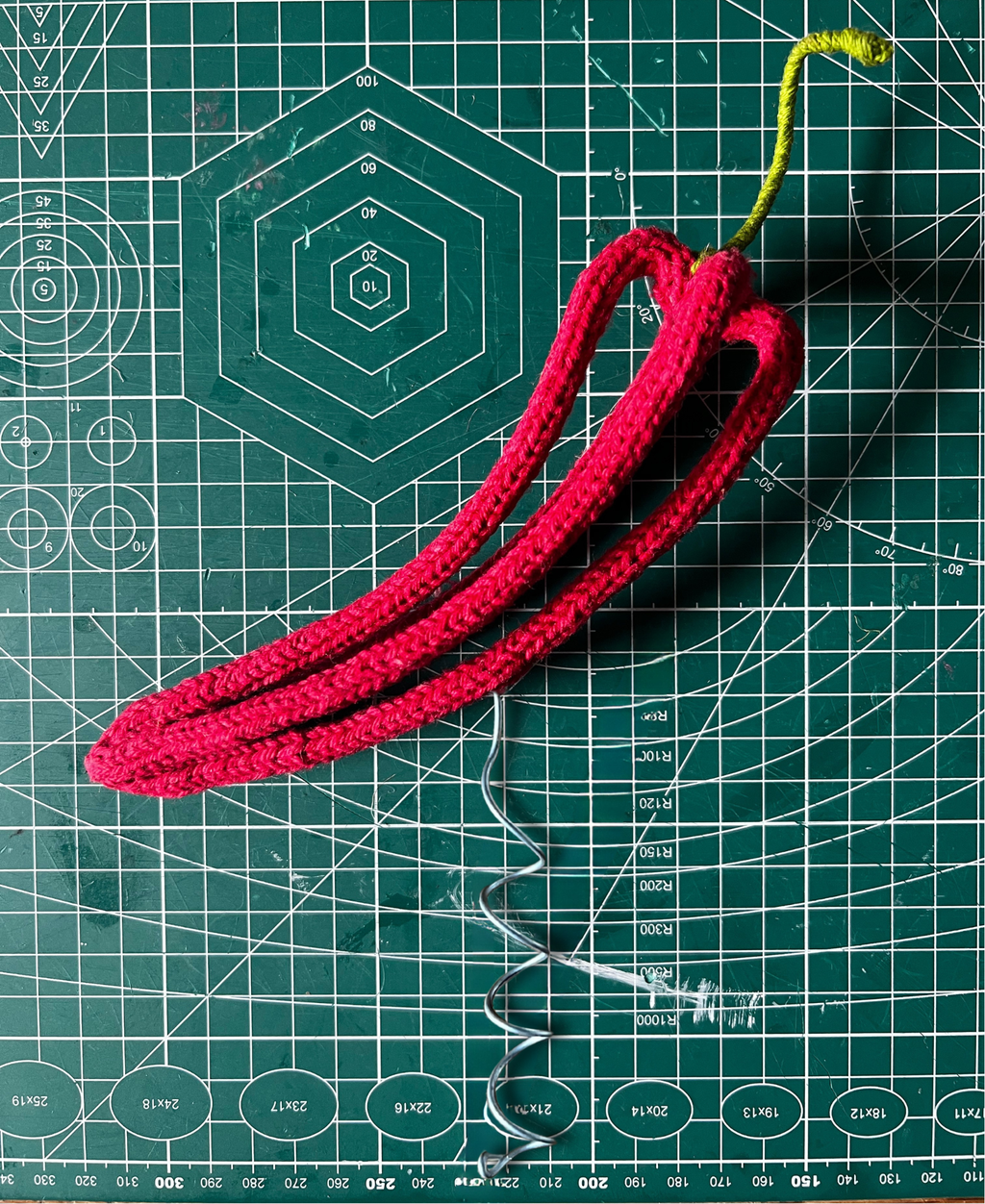 French knitted and wire sculpted red chilli tree topper green cutting mat