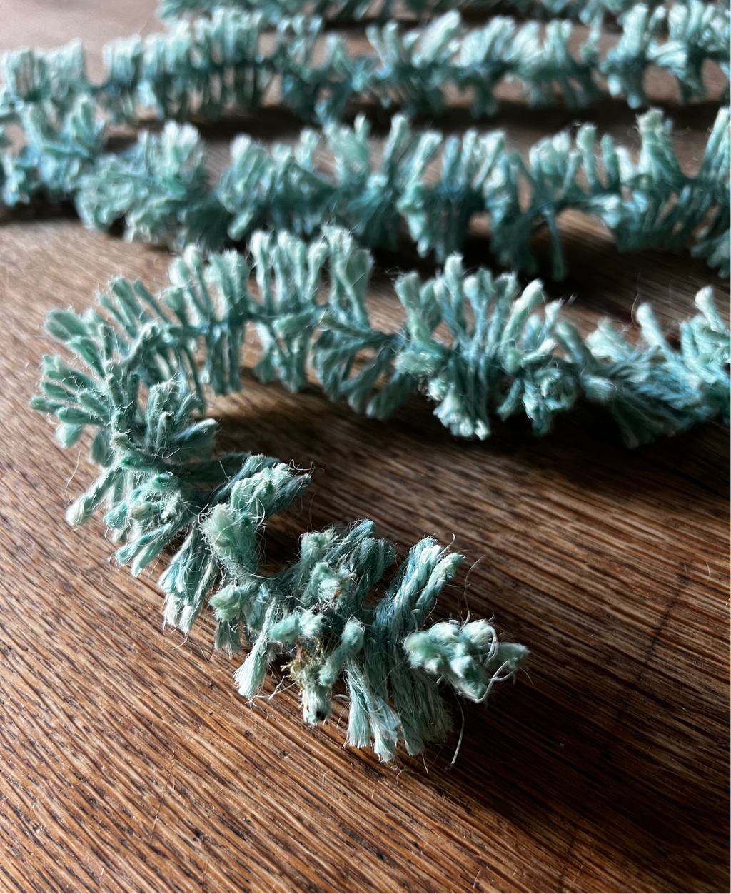Duck Egg blue Strinsel jute string tinsel on a wooden background