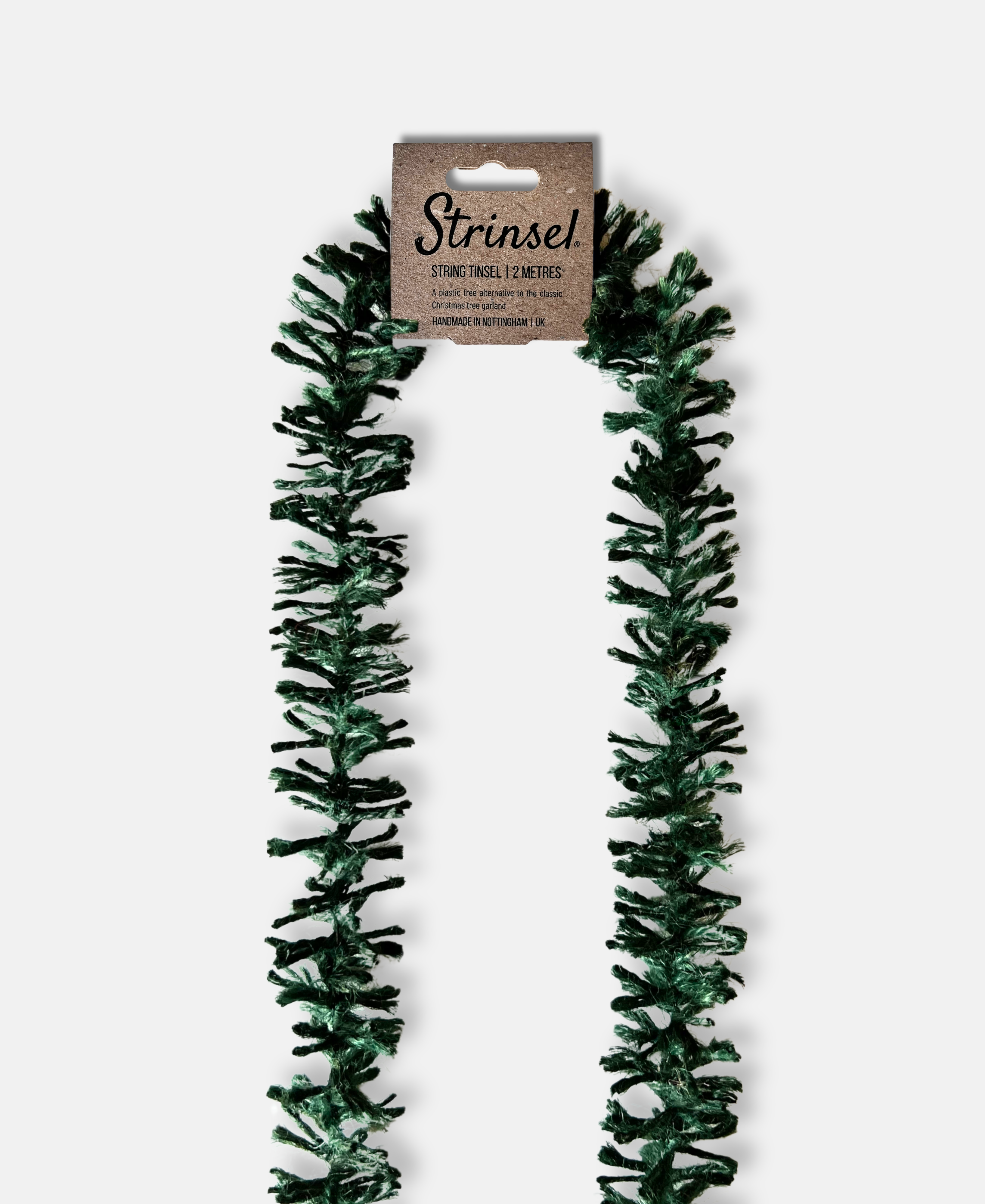 Forest Green Strinsel jute string tinsel with packaging on a pale grey background