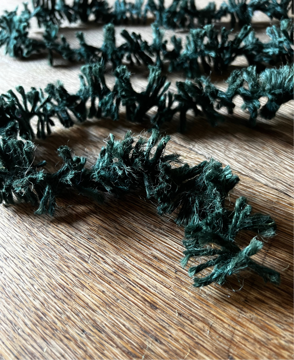 Forest Green Strinsel jute string tinsel without packaging on a wooden background