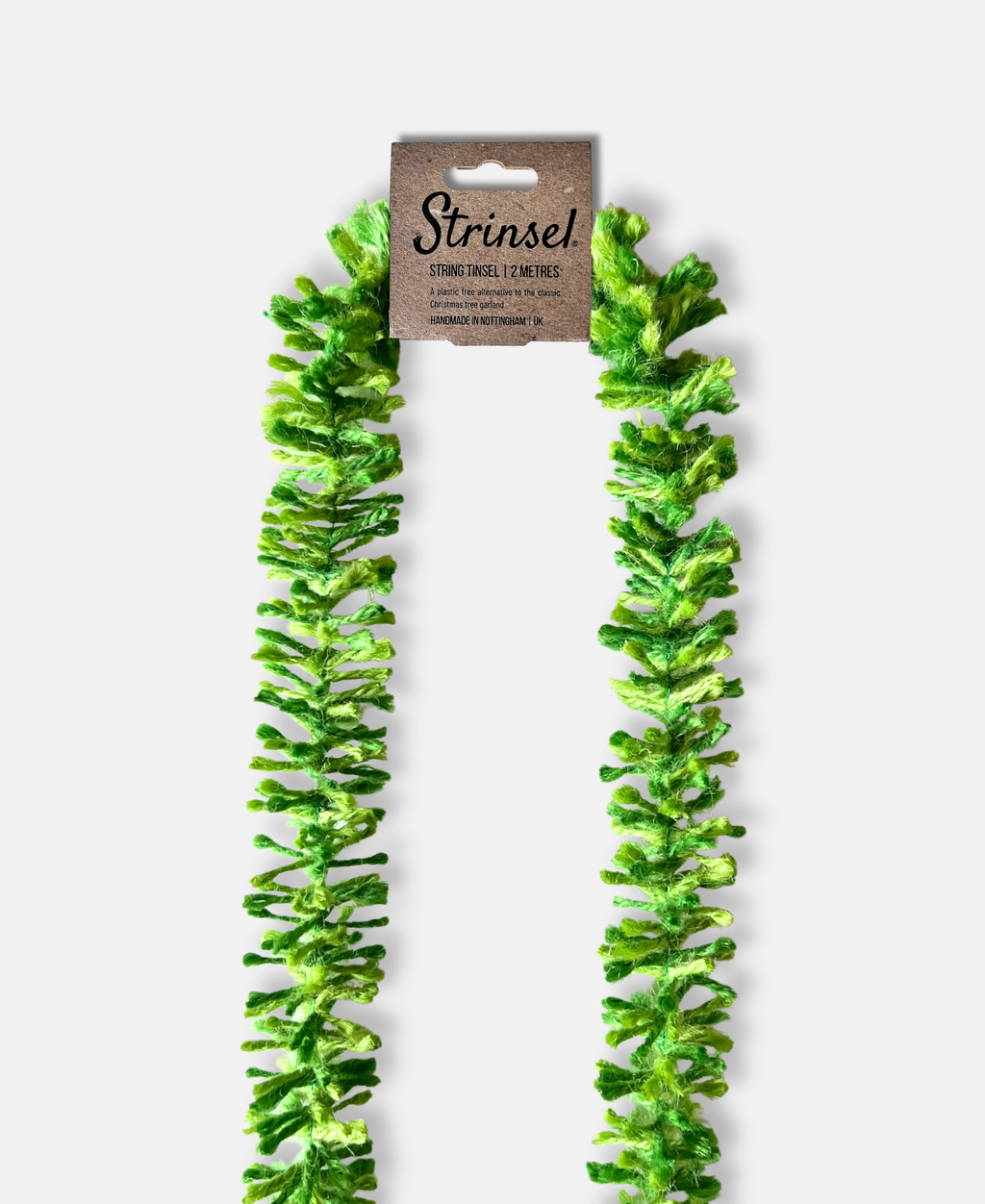 Green pop Strinsel jute string tinsel with packaging on a pale grey background