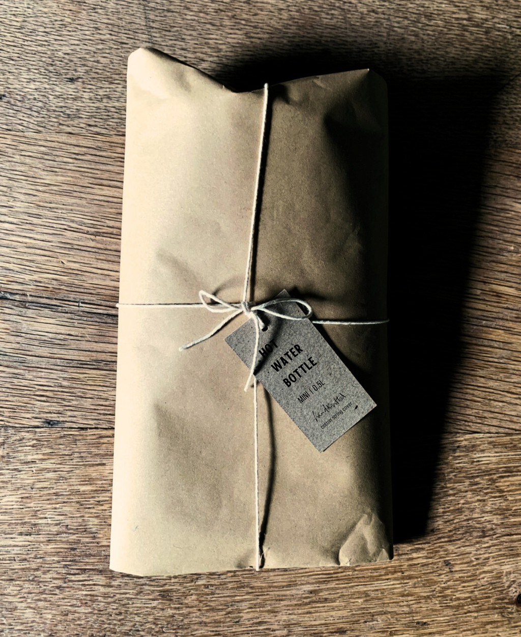 Kraft paper-wrapped package with a tag on a wooden surface