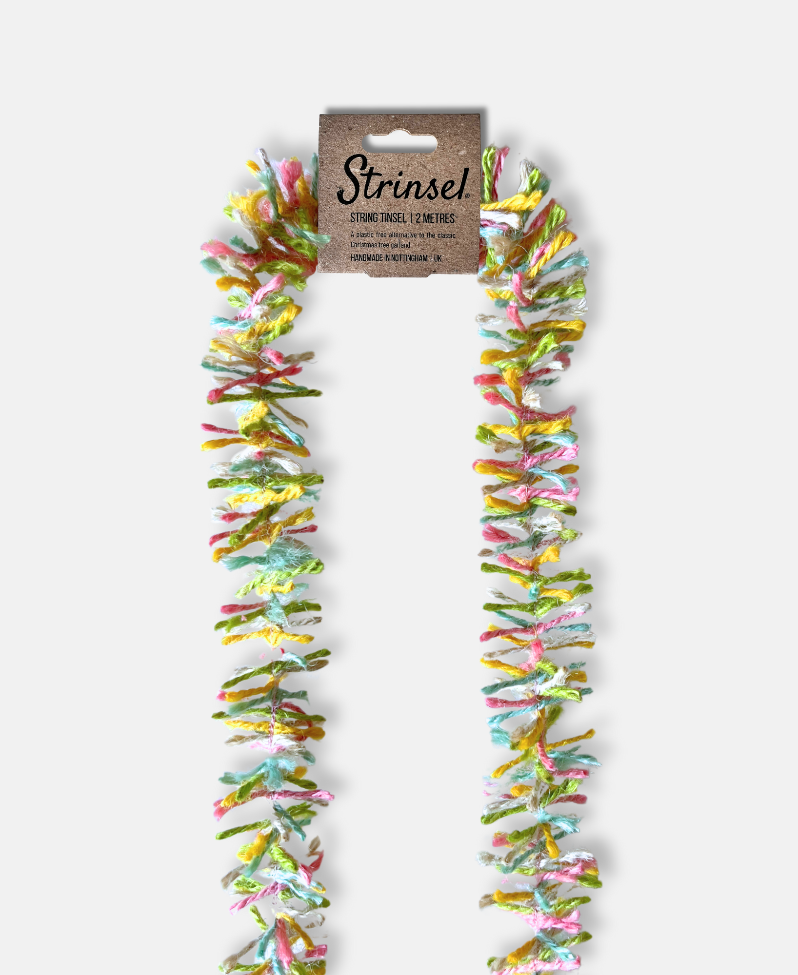Pastel Pop Strinsel jute string tinsel with packaging on a pale grey background.