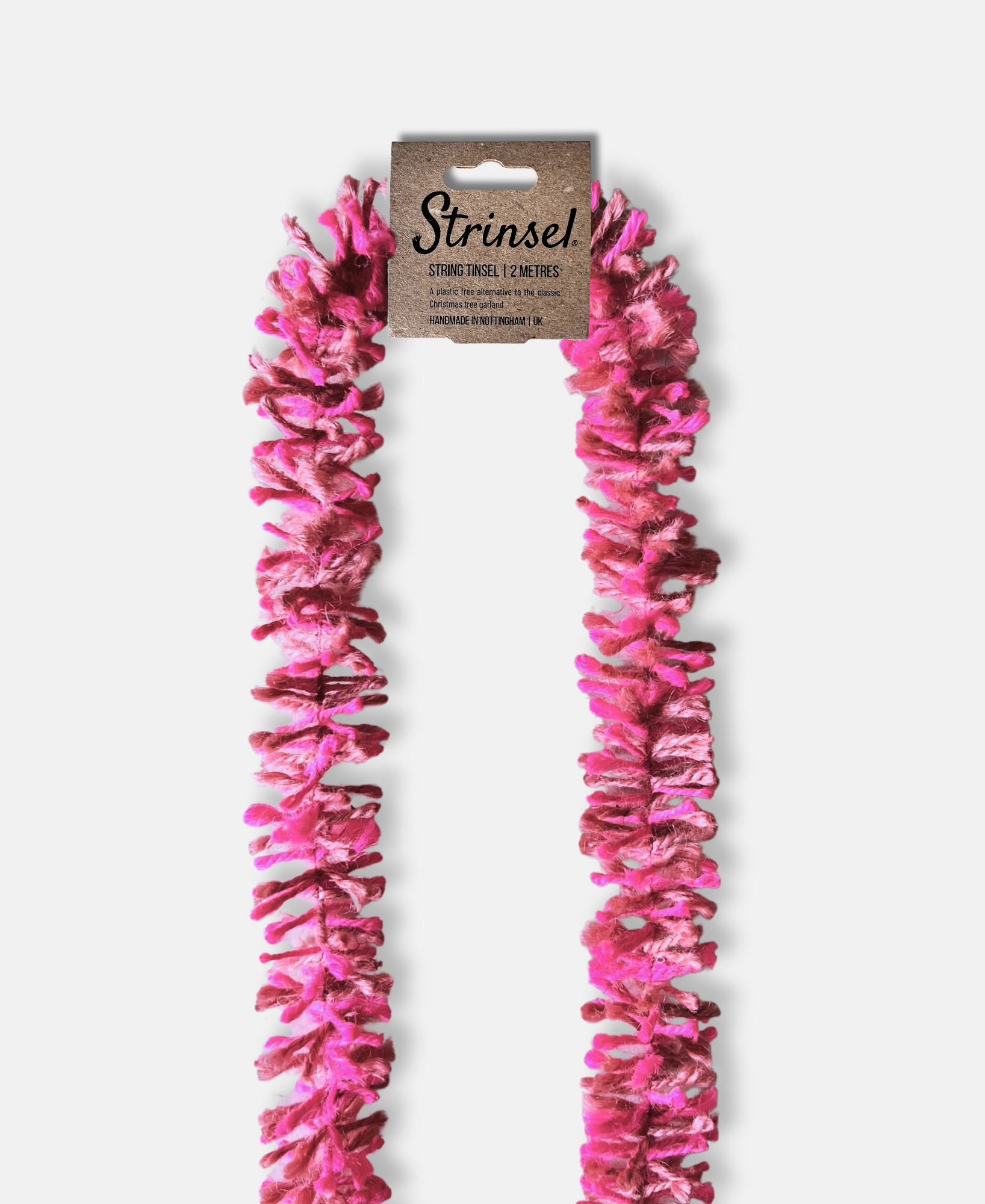 Pink Pop Strinsel jute string tinsel with packaging on a pale grey background