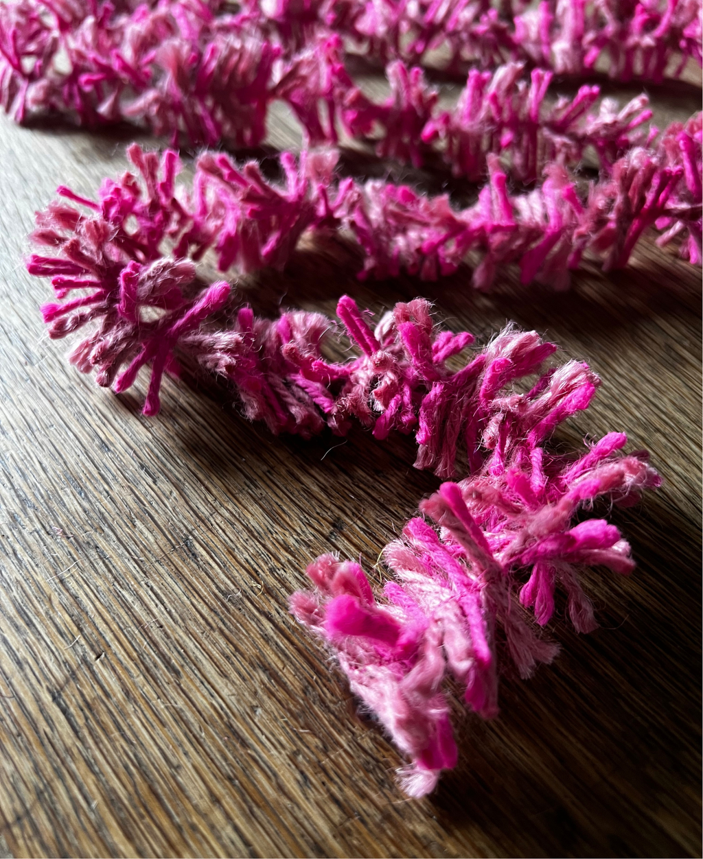 Pink Pop Strinsel jute string tinsel on a wooden background