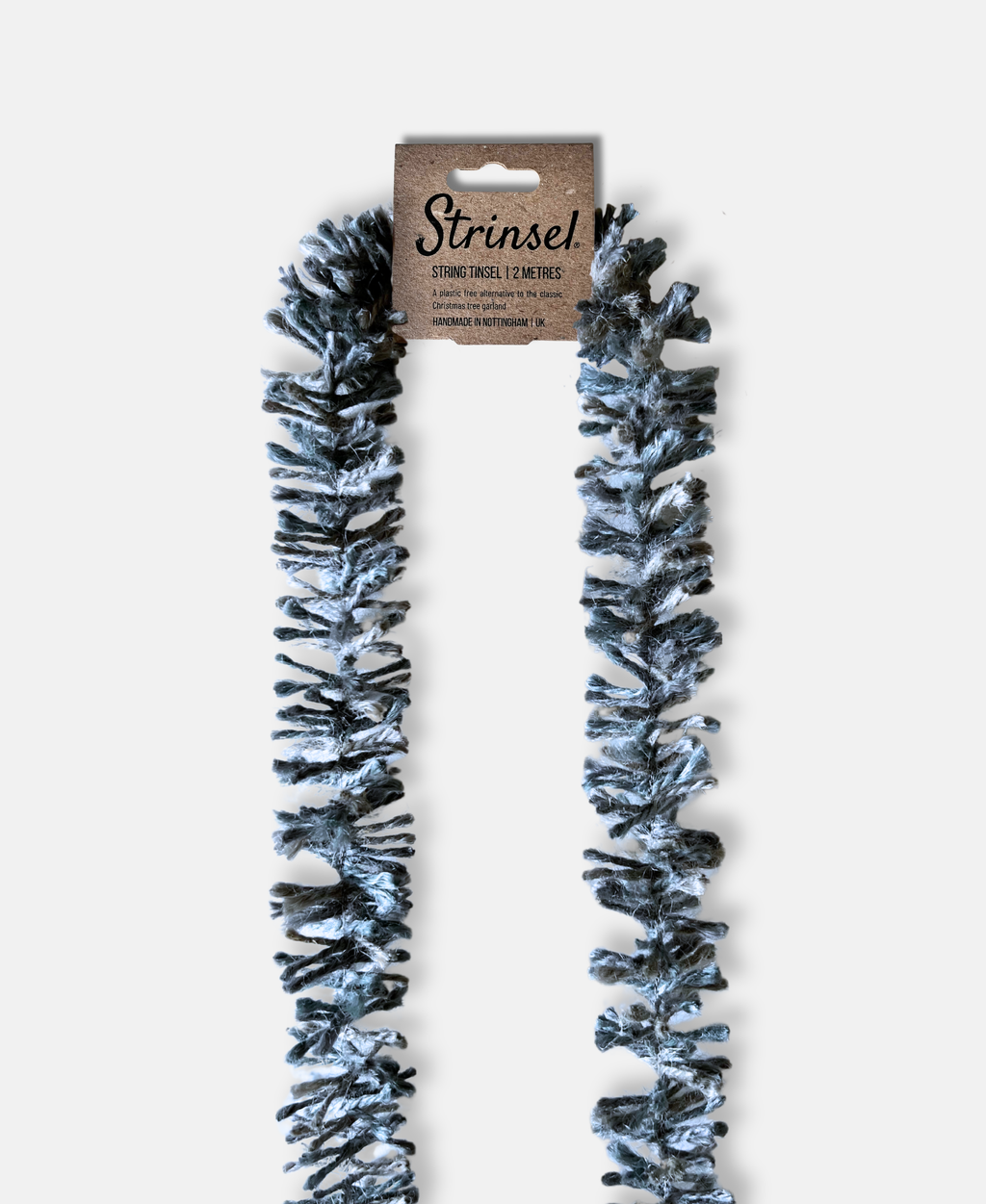Silvery Pewter Strinsel jute string tinsel with packaging on a pale grey background