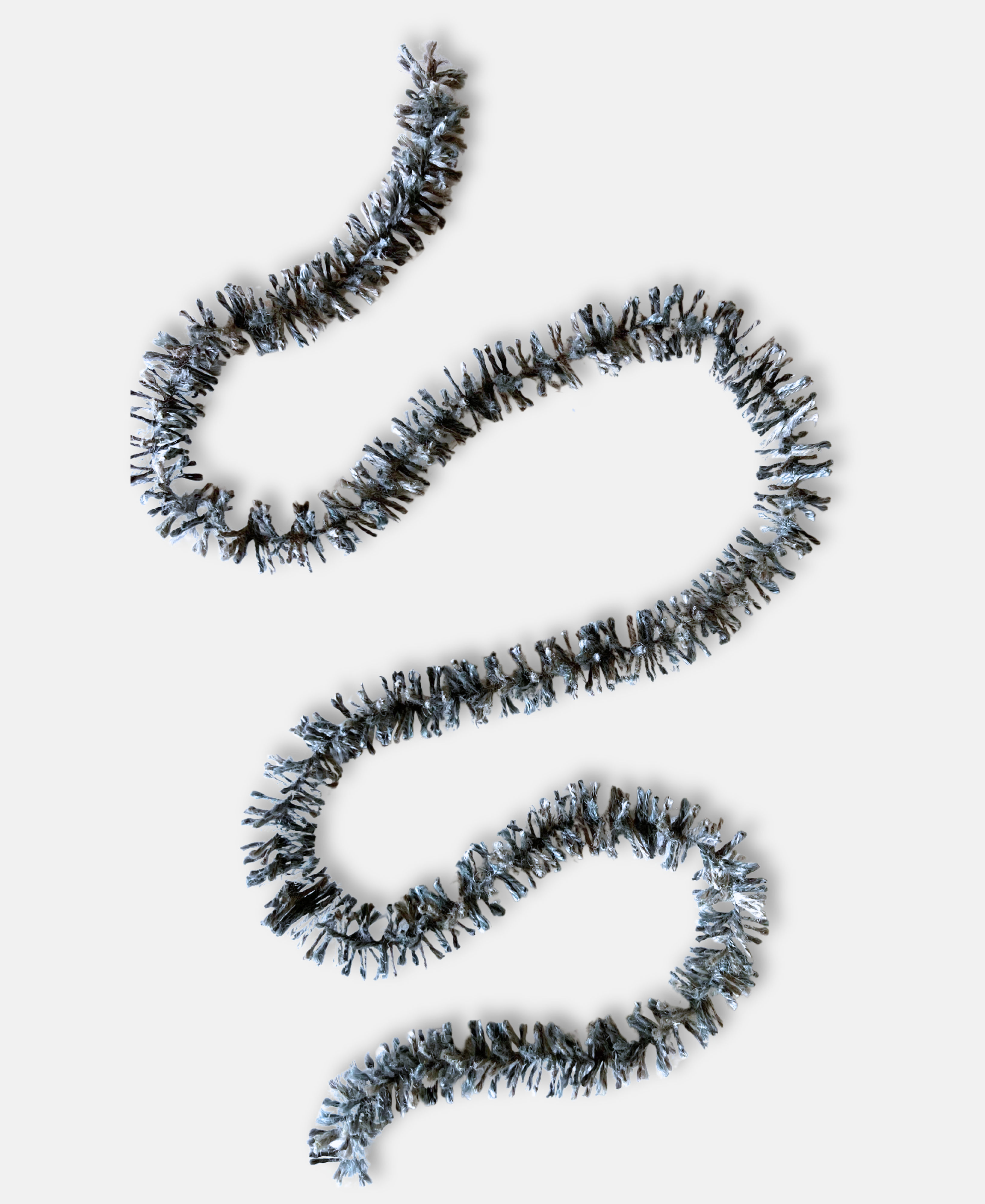 Silvery Pewter Strinsel jute string tinsel without packaging on a pale grey background