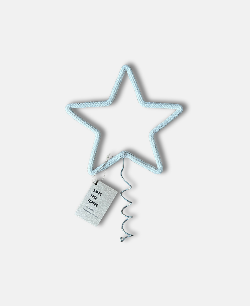 Star-shaped Christmas tree topper with a tag on a white background