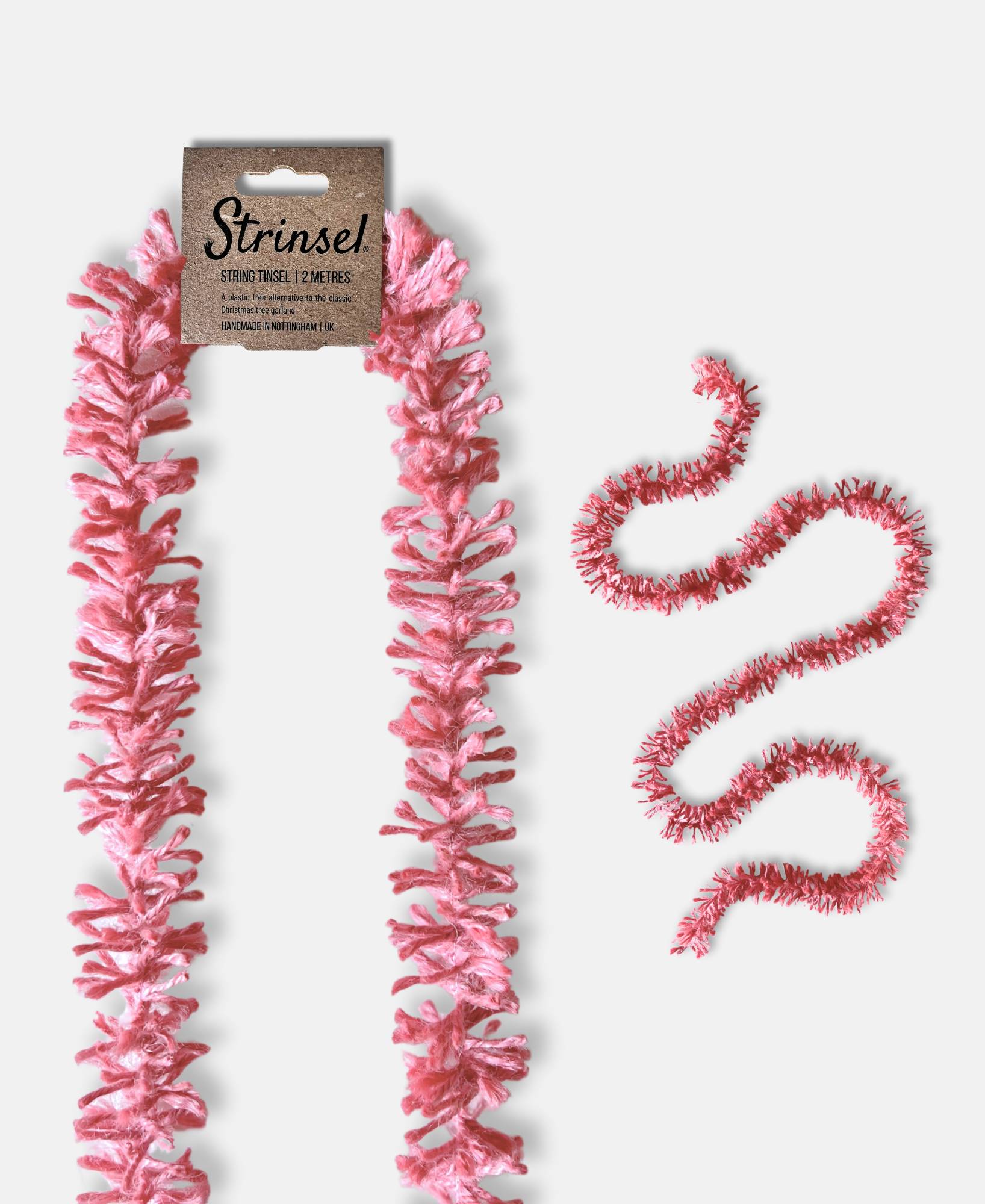 Soft pink Strinsel jute string tinsel with and without packaging on a pale grey background