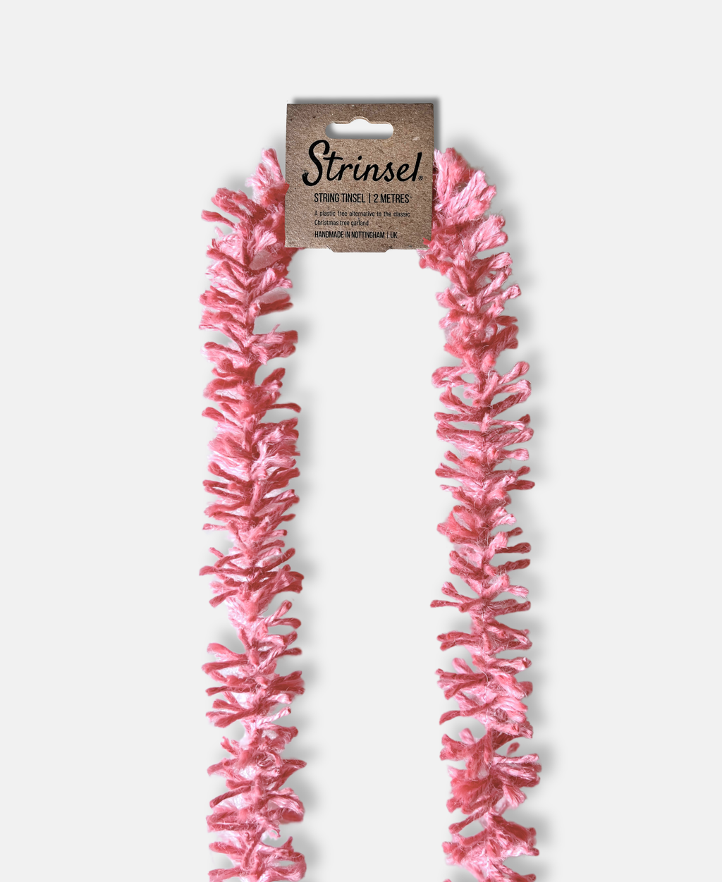 Soft pink Strinsel jute string tinsel with packaging on a pale grey background