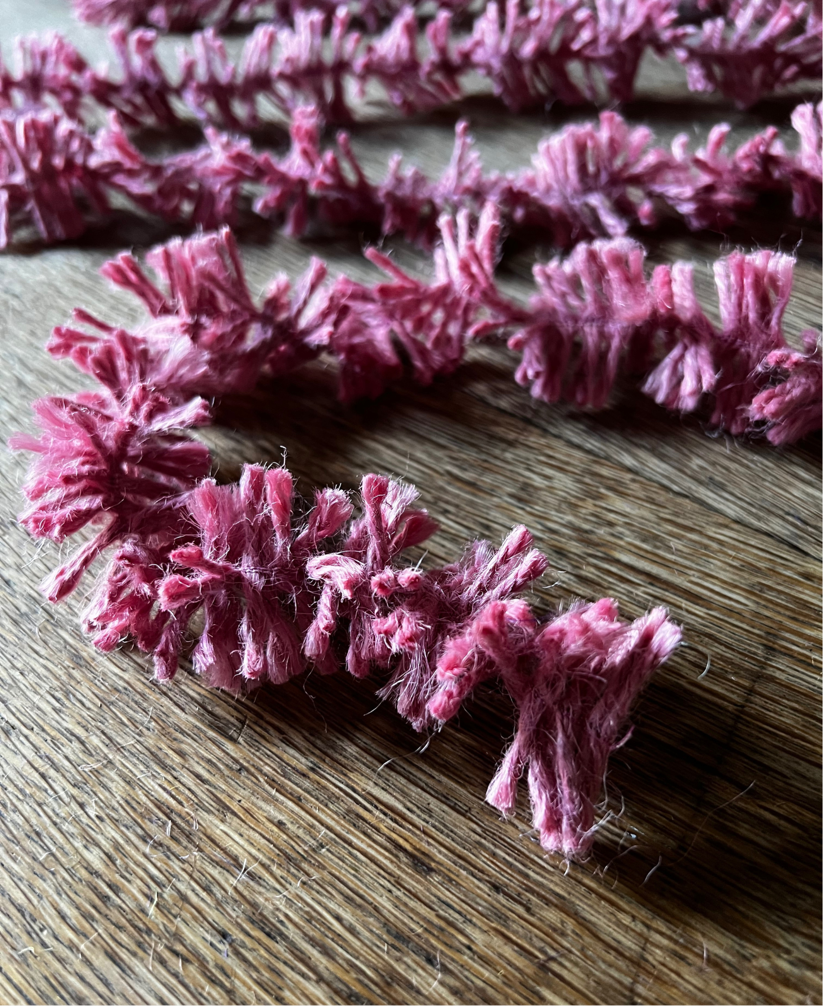 Soft pink Strinsel jute string tinsel on a wooden background