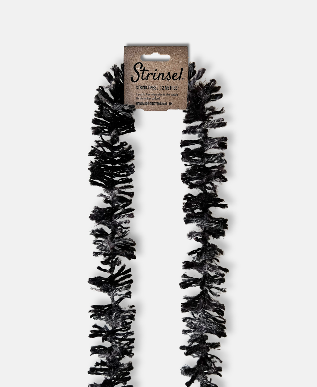 Halloween themed black jute spider leg Strinsel string tinsel with kraft label laid flat on a white background