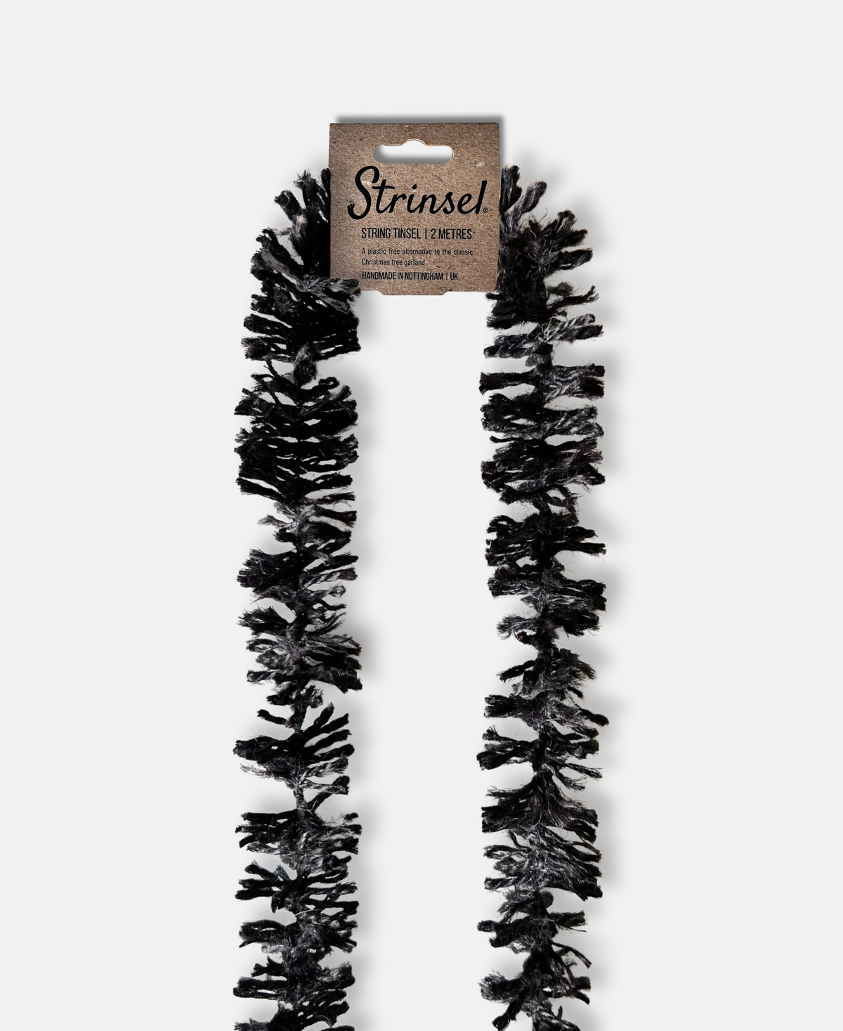 Halloween themed black jute spider leg Strinsel string tinsel with kraft label laid flat on a white background