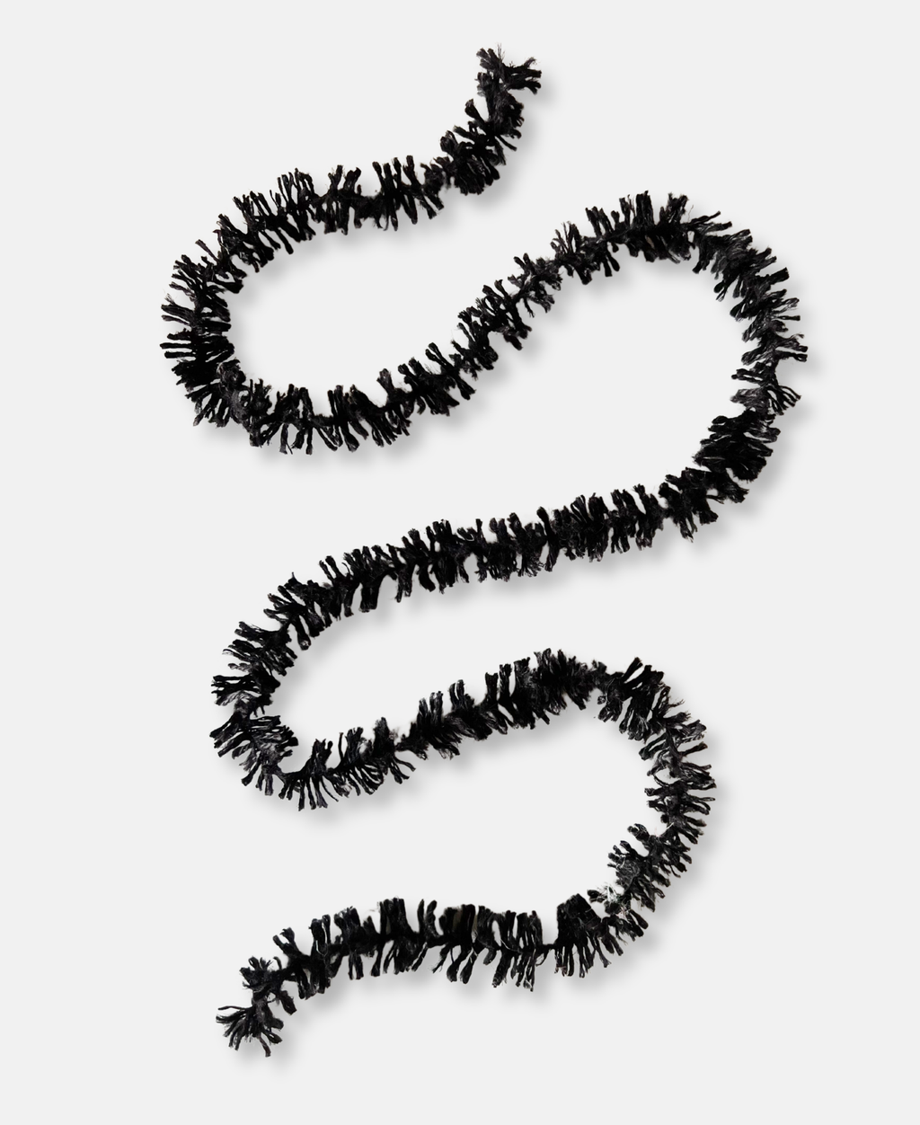 Black jute spider leg like Strinsel string tinsel squiggled on a white background