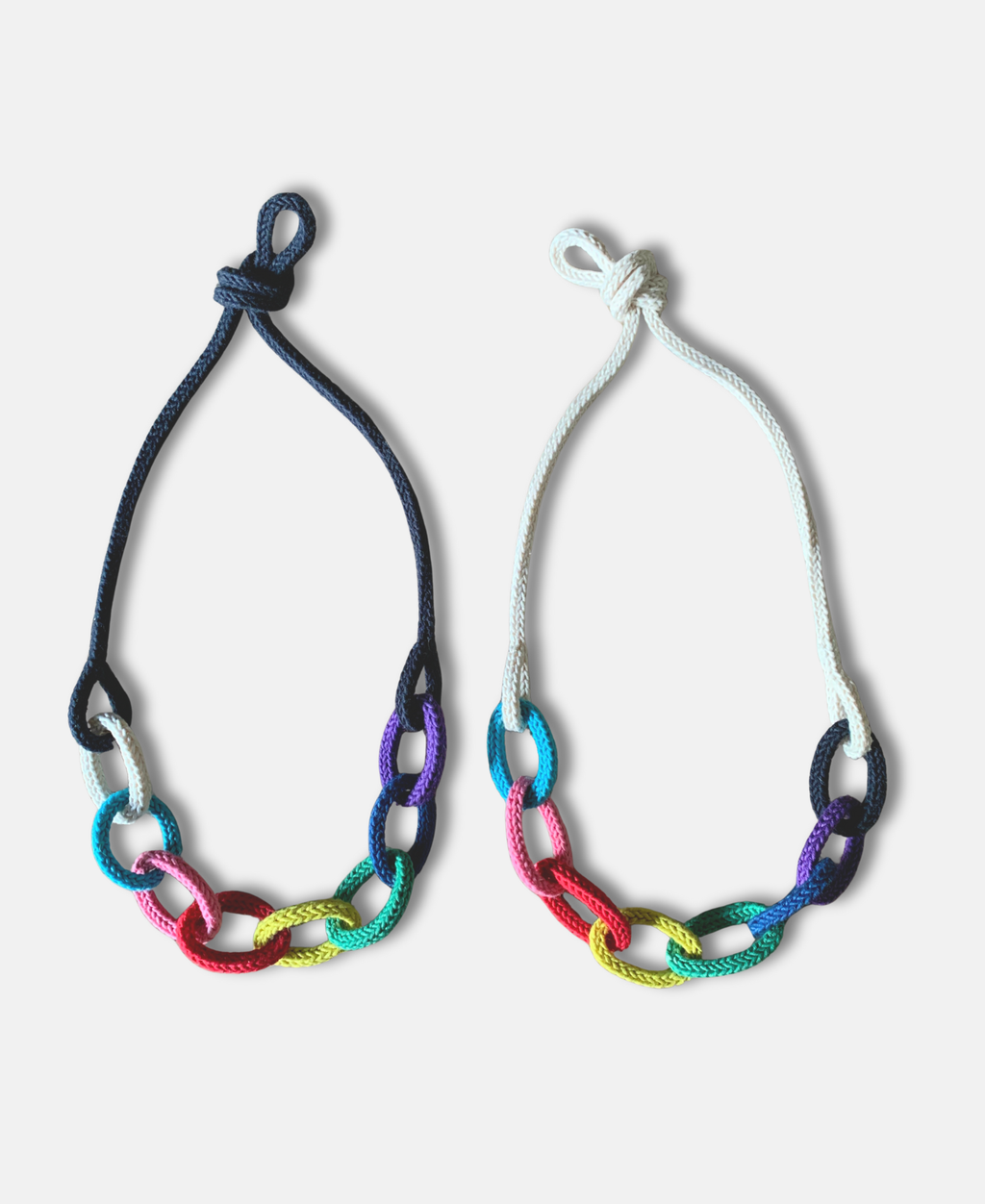 Two knotted rainbow themed chunky chain "string bling" necklaces on a white background