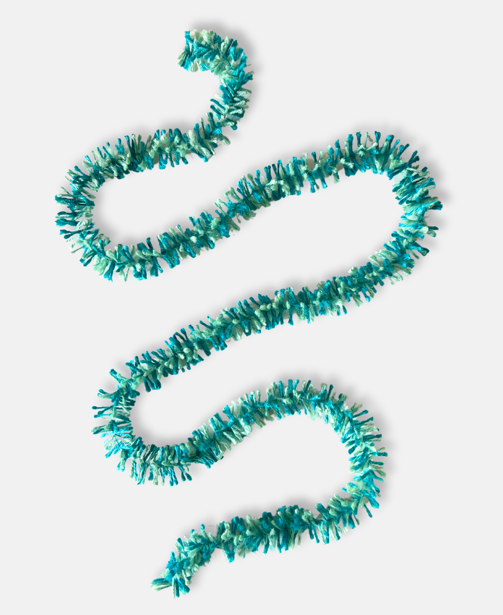Teal and aqua Strinsel jute string tinsel on a pale grey background